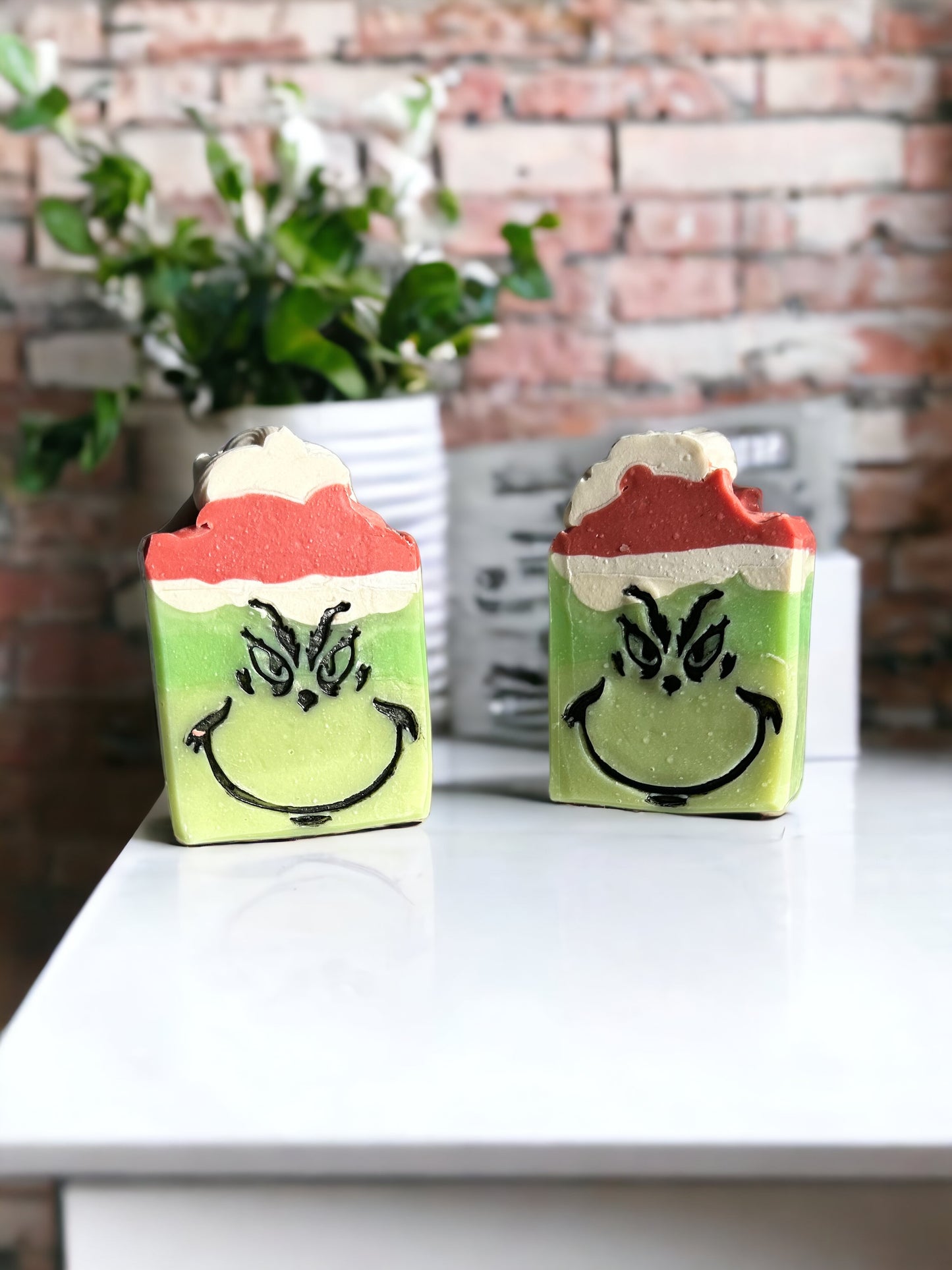 green soap with red and white santa hat sitting on white table 