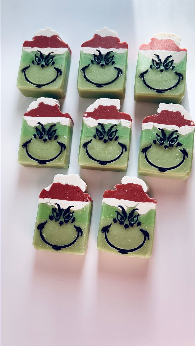 multiple green soaps with red and white santa hats lying on a white background 